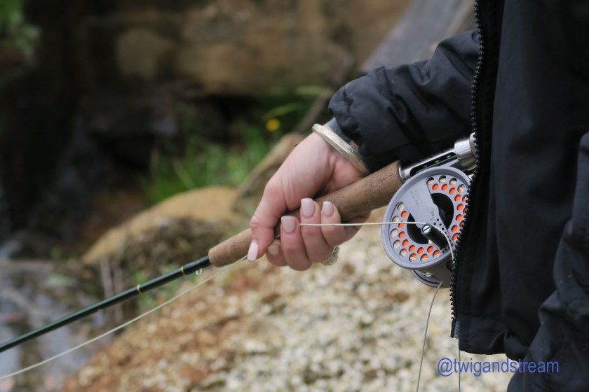 Ladies hand holding a fly rod.